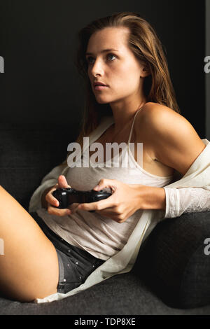 Woman playing video game in living room at home Stock Photo