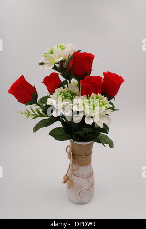 Clay vase painted with red roses and white daisies Stock Photo