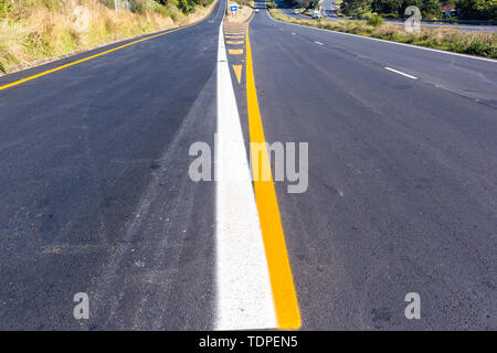 Road highway new asphalt tarmac painted white yellow exit markings directions lines closeup middle overhead photo detail. Stock Photo