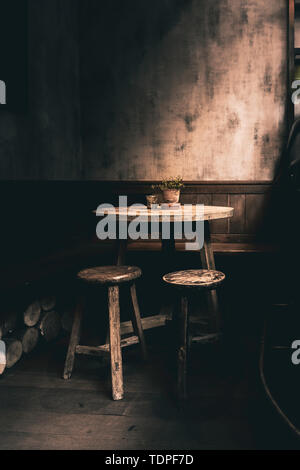 Dramatic photo a woodent table and chairs in a corner of a English Pub Stock Photo