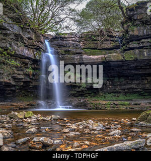 Summerhill Force is a picturesque waterfall in a wooded glade in Upper Teesdale. Heavily undercut, the recess behind the fall is known as 'Gibson's... Stock Photo