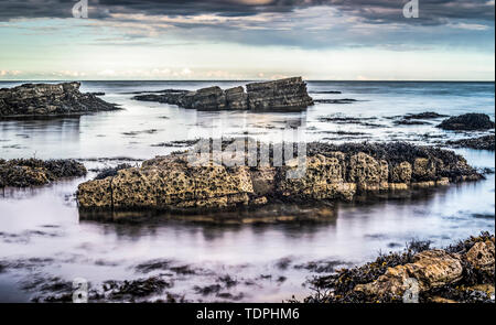 Rocks at low tide at sunset along the coast; Whitburn, Tyne and Wear, England Stock Photo