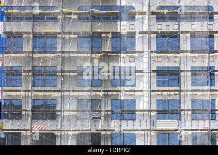 building facade under construction with scaffolding and protective net Stock Photo