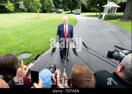 President Donald Trump talking with the press near the White House South Lawn just prior to getting on Marine One, to start his trip to Florida where he is to appear at a rally there, at the White House in Washington, DC. Stock Photo