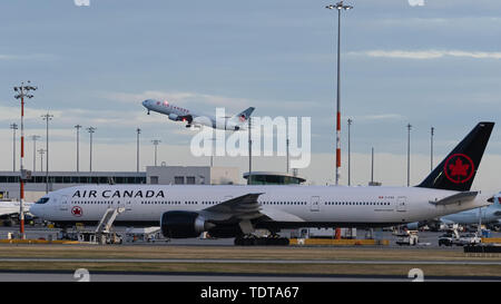 Richmond, British Columbia, Canada. 17th June, 2019. Boeing jets belonging to Air Canada at Vancouver International Airport. In the foreground a Boeing 777-300ER is parked on the tarmac, in the background a Boeing 767 is airborne after take-off. Credit: Bayne Stanley/ZUMA Wire/Alamy Live News Stock Photo