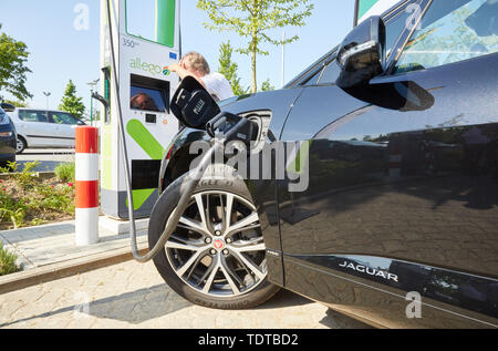 Hamburg, Germany. 19th June, 2019. A Jaguar I-Pace is standing at an ultra-fast charging station with up to 350 kW charging power during a press appointment. The operator of charging solutions 'Allego' opened its first high-performance charging location for electric vehicles in Germany on the parking lot of the garden centre 'Garten von Ehren' in Harburg. The charging time at this column is less than 5 minutes for 100 km range. Credit: Georg Wendt/dpa/Alamy Live News Stock Photo
