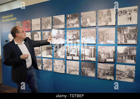 Rostock, Germany. 19th June, 2019. Steffen Stuth, museum director, shows a wall with photos on the topic 'University in Socialism' in the new exhibition 'People - Knowledge - Life Paths' at a press event in the Monastery of the Holy Cross. Starting 20.06.2019, the show will present exciting aspects from 600 eventful years of Rostock university and science history. Credit: Bernd Wüstneck/dpa-Zentralbild/dpa/Alamy Live News Stock Photo