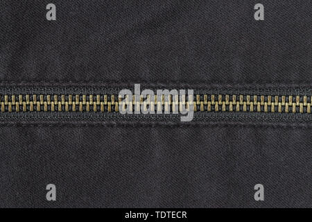Brass Zip on Black Jeans Texture Background. Closed Brass Zip on Black Jeans Texture Background for Apparel Design Stock Photo