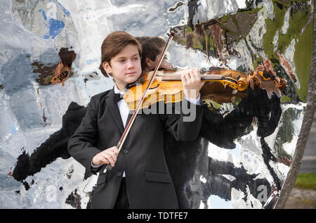 Viktor Seifert, 12, from St Mary's Music School in Edinburgh, plays the Orca Driftwood Viola alongside the giant mussel shell sculpture at Musselburgh, East Lothian, ahead of his performance at the Royal Academy of Music in London on July 18th 2019, in the 'Dance For The Sea' event which supports the work of the Marine Conservation Society. Stock Photo