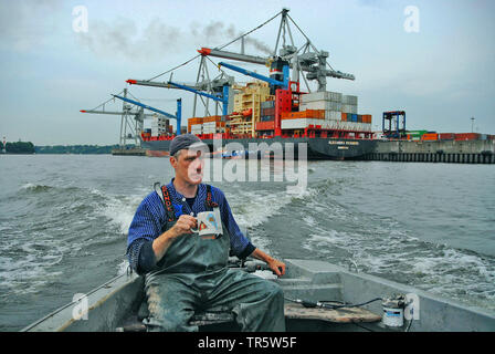 fischerman in a fishing boat on Elbe river in the Port of Hamburg, Germany, Hamburg Stock Photo