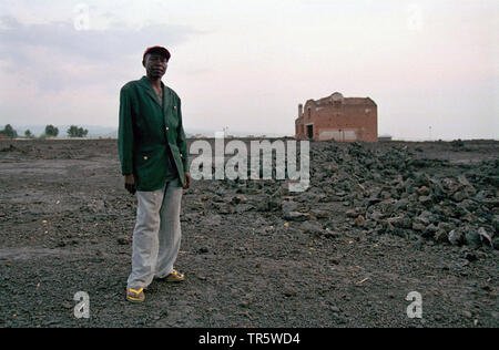 man standing in front of a new house, Republic of the Congo, Goma Stock Photo
