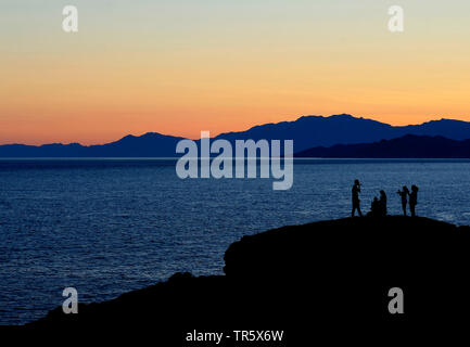 persons on a coastal rock in the morning near the village of Ile Rousse in north of Corsica island, France, Corsica, Ile Rousse Stock Photo