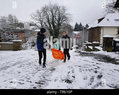 children with ski bob on a street, Germany, North Rhine-Westphalia, Ruhr Area, Witten Stock Photo