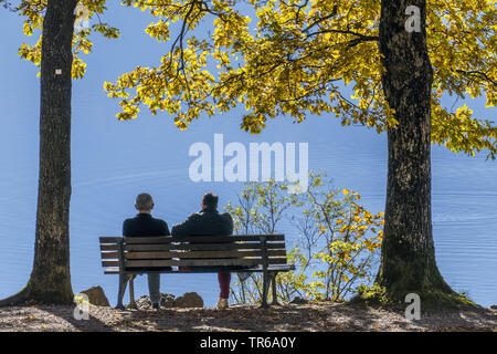 couple on a bench at lake Kochel in autumn, Germany, Bavaria, Oberbayern, Upper Bavaria, Kochel Am See Stock Photo