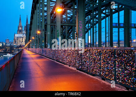 Hohenzollern Bridge with love padlocks, Cologne Cathedra in background in the evening, Germany, North Rhine-Westphalia, Rhineland, Cologne Stock Photo