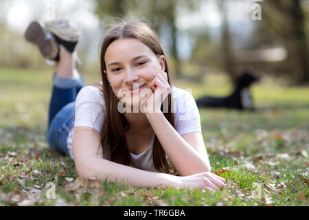young woman lying on lawn, Germany Stock Photo