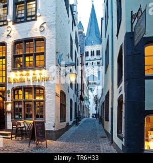 Salzgasse with restaurant, view through narrow lane to Great St. Martin Church in the evening, Germany, North Rhine-Westphalia, Cologne Stock Photo