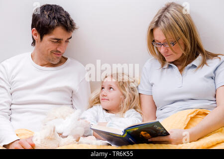 parents and daughter together in a bed Stock Photo