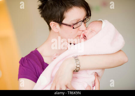 mother kisses her crying baby Stock Photo