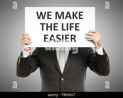 businessman holding a sign with the inscription We make the Life easier, Germany Stock Photo