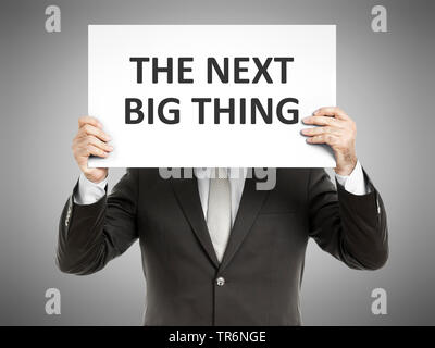 businessman holding a sign with the inscription the next big thing, Germany Stock Photo