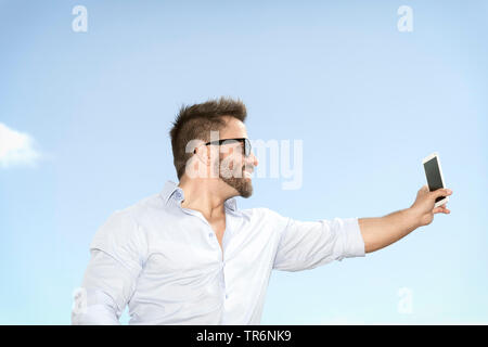 muscular man in nature doing a selfie, Germany Stock Photo