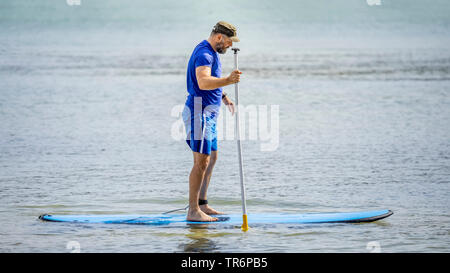bearded man paddling in the ocean, Germany Stock Photo