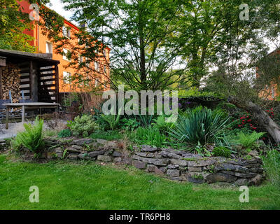 raised bed with natural stone wall in summer, Germany Stock Photo