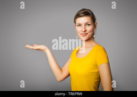 young woman, who presenting someting on her palm, Germany Stock Photo