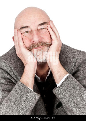 old man with bald head and grey beard resting his head on hands, Germany, Bavaria Stock Photo