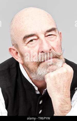 Portrait of old, baldheaded man with grey beard looking at camera. Stock Photo