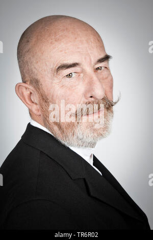 old man in a back jacket with bald head and grey beard, Germany, Bavaria Stock Photo