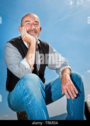 old man with a grey beard relaxing at the lake, Germany Stock Photo
