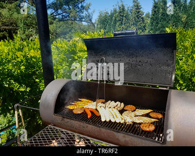 grill meat in a Barbecue-Smoker on a terrace, Germany Stock Photo