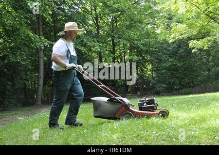 gardener mowing the lawn, Germany, North Rhine-Westphalia Stock Photo