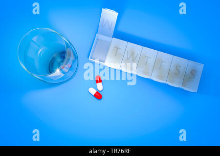 3d rendering of a reminder box for pills and a glass of water Stock Photo