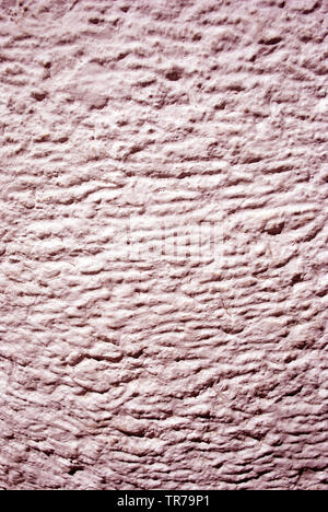 Wall with pink plaster imitating waves on water surface, grunge texture background Stock Photo