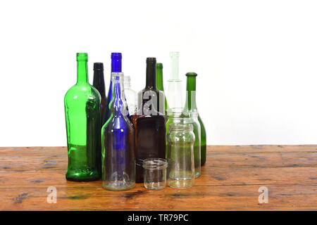 group of bottles and glass jars on a wooden table with white background Stock Photo