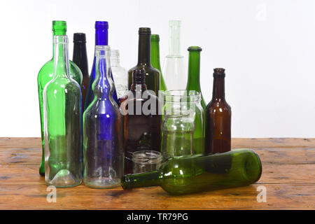 group of bottles and glass jars on a wooden table with white background Stock Photo