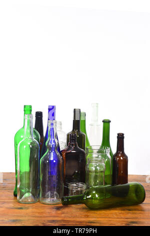 group of bottles and glass jars on a wooden table with white background Stock Photo
