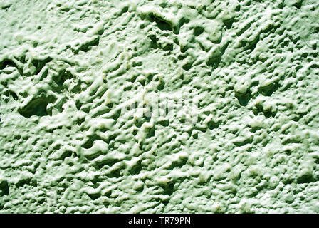 Wall with pastel green plaster imitating waves on water surface, grunge texture background Stock Photo