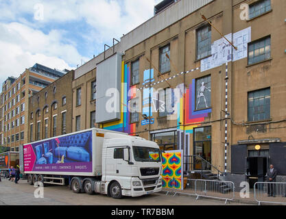 LONDON SPITALFIELDS BRICK LANE AREA GAFFITI AND WALL ART ON LARGE BUILDING AND FOUR LARGE ARROWS FROM BORIS JOHNSONS BOW Stock Photo
