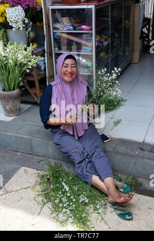 Indonesian flower arranger in the Java village of Kampung Pelangi Stock Photo