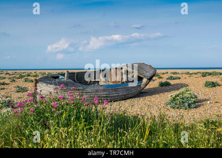 Abandoned wooden fishing boat on a pebble beach Stock Photo