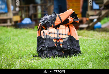 Colorful life jackets safety equipment on green meadow Stock Photo