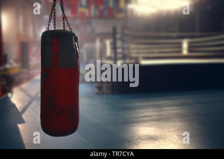 a red sanbag is hanging in front of the boxing ring in a gym for shooting a movie Stock Photo