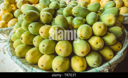 Heap of fresh ripe Dashehari mangoes in basket at fruits shop. Stock Photo