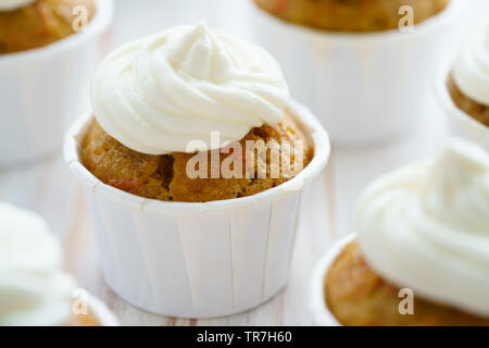 Carrot cupcakes with vanilla frosting. White wooden table, high resolution Stock Photo