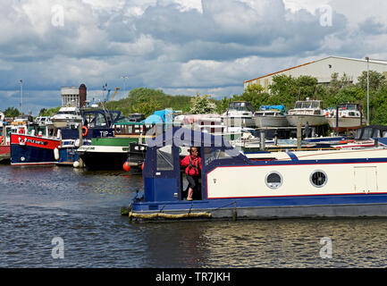 Woman and narrowboat, and boats moored in the marina, Goole, East Yorkshire, England UK Stock Photo