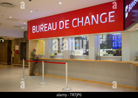 Bureau de change foreign exchange currency converter kiosks with a tourist at the counter doing some business at Cape Town International Airport
